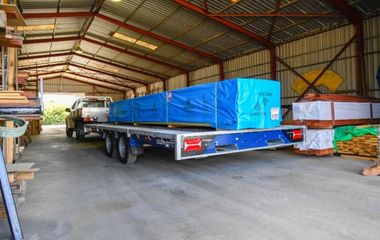 Photo of a large trailer and ute driving through the timber yard, the One-Stop Shop for Building Supplies.