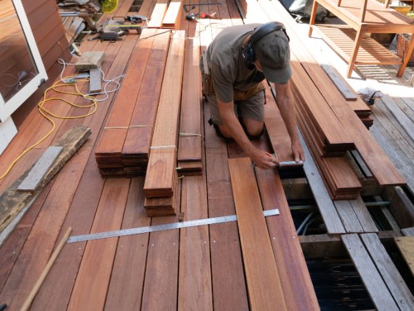 A photo of a man measuring Jarrah hardwood