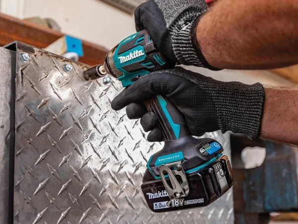 Makita XDT16 brushless impact driver fastening into metal with a nutsetter bit.