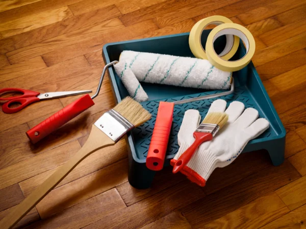 Essential painting tools including roller tray, brushes, tape and gloves needed for a simple room refresh. All available from Geographe Timber & Hardware.